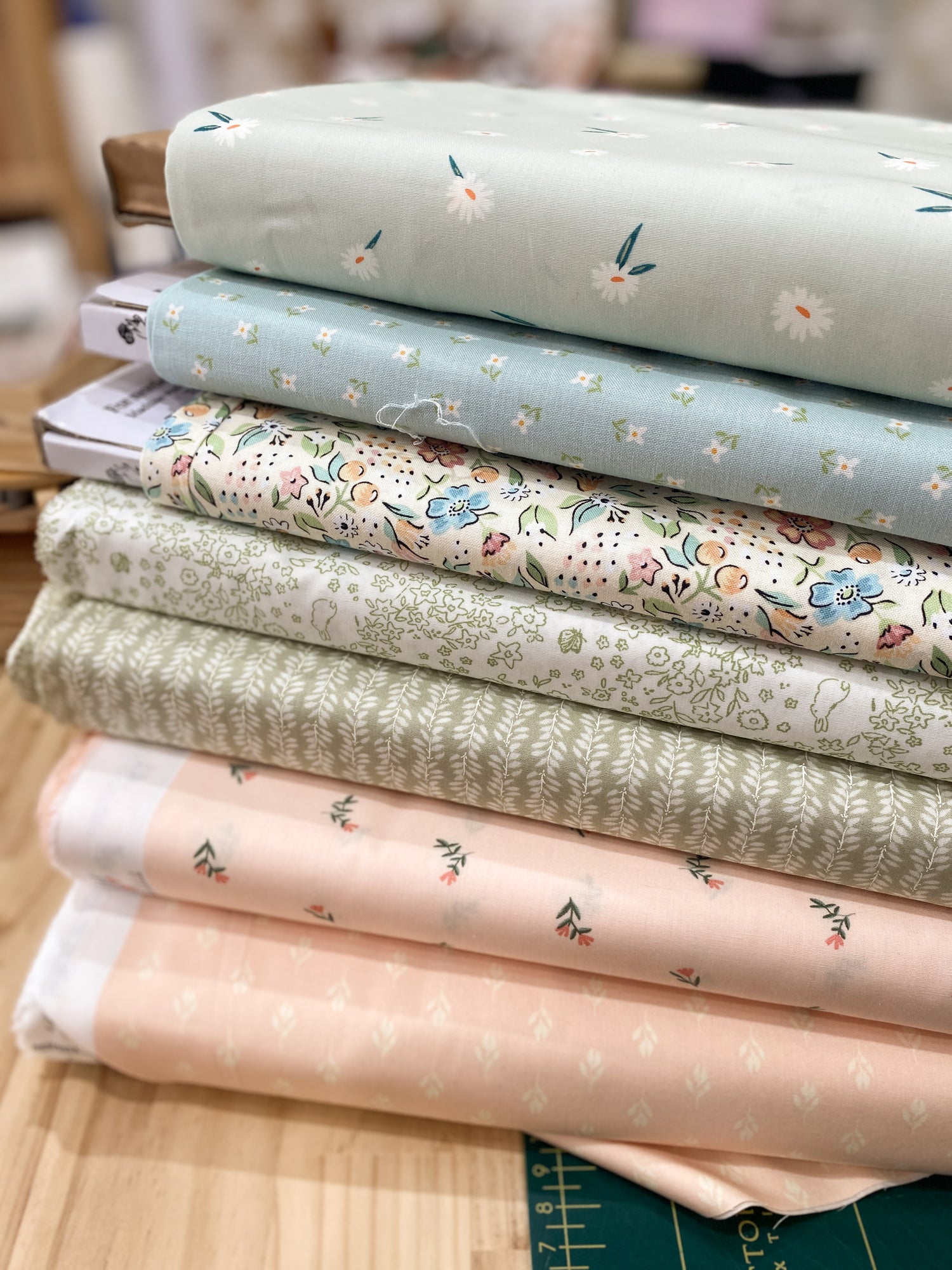 Collection of light green,pink and blue fabrics with soft floral patterns