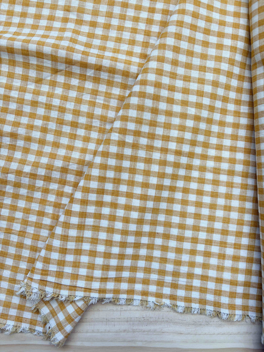 Close up of fabric with yellow and white check gingham pattern